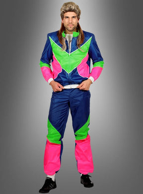 Eine Person, gekleidet in einen Neon-Retro-Trainingsanzug im Stil der 80er Jahre – einen farbenfrohen Trainingsanzug im Stil der 1980er Jahre in den Farben Blau, Grün und Pink –, kombiniert mit einer langen Vokuhila-Perücke, steht vor einem grauen Hintergrund mit Farbverlauf. Dieses auffällige Outfit ist ideal für alle, die auf der Suche nach einem authentischen 80er-Jahre-Kostüm sind.