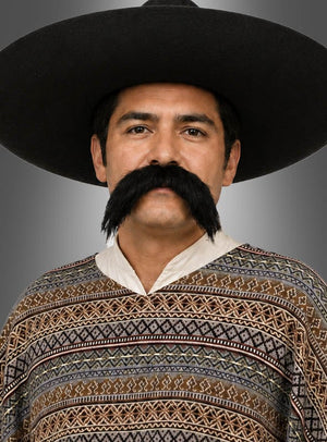 Ein Mann mit einem schwarzen Hut mit breiter Krempe, einem großen, beeindruckenden Schnurrbart und einem gemusterten Poncho steht vor einem grauen Hintergrund. Dieser beeindruckende Schnurrbart rundet sein auffälliges Oberlippenbart-Kostüm ab.