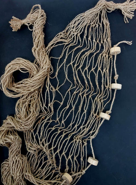 Ein locker gewundenes, braunes Jutenetz mit daran befestigten Holzringen, ausgebreitet auf einer dunklen Unterlage – perfekt als „Fischernetz-Deko aus Jute 200–400 cm“ für Ihre nächste maritime Gartenparty.