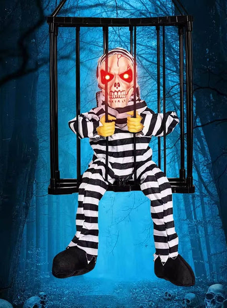 Die „Animierte Halloween-Figur im Käfig“ zeigt ein Skelett in einem schwarz-weiß gestreiften Gefängnisanzug mit leuchtend roten Augen, das vor dem Hintergrund eines gruseligen Waldes in einem Käfig sitzt. Diese animierte Horrorpuppe ist die ideale Grusel-Dekoration und verleiht Ihrer Sammlung von Halloween-Figuren im Käfig eine unheimliche Atmosphäre.
