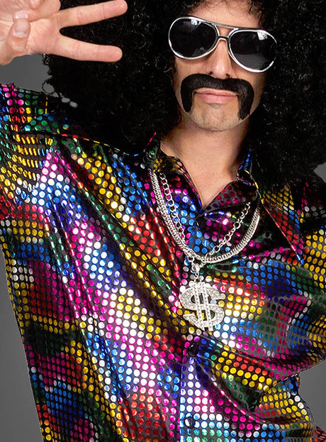 Eine Person, die ein knalliges „Disco Fever Rainbow Glitter“-Hemd trägt – komplett mit buntem Paillettenhemd, einer großen Dollarzeichen-Halskette, einer lockigen Perücke, einem falschen Schnurrbart und einer Sonnenbrille – und dabei das Peace-Zeichen macht: das perfekte 70er-Jahre-Kostüm!.