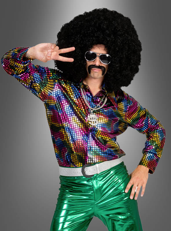 Eine Person, die ein leuchtendes „Disco Fever Rainbow Glitter“-Hemd, eine grün-metallische Hose, eine übergroße Afro-Perücke, eine Sonnenbrille und einen falschen Schnurrbart trägt, posiert vor einem grauen Hintergrund mit dem Peace-Zeichen – perfekt für ein authentisches 70er-Jahre-Kostüm.