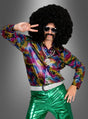 Eine Person, die ein leuchtendes „Disco Fever Rainbow Glitter“-Hemd, eine grün-metallische Hose, eine übergroße Afro-Perücke, eine Sonnenbrille und einen falschen Schnurrbart trägt, posiert vor einem grauen Hintergrund mit dem Peace-Zeichen – perfekt für ein authentisches 70er-Jahre-Kostüm.
