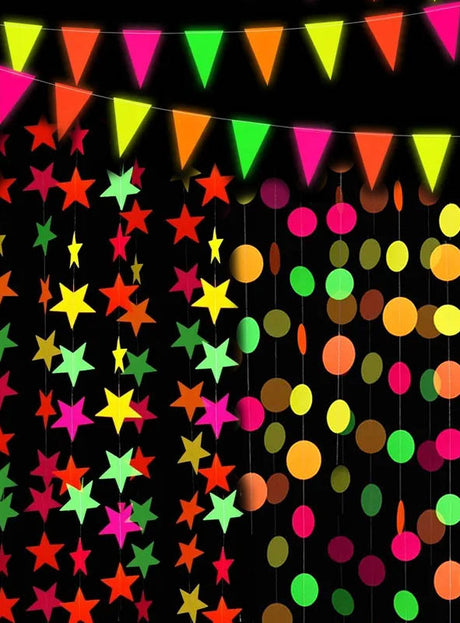 Bunte Papiersterne, Kreise und Dreiecke hängen an Schnüren vor einem schwarzen Hintergrund und bilden eine festliche Partydekoration – perfekt als „80er-Jahre-Neon-Girlande 440 cm“ für Ihre nächste UV-leuchtende Schwarzlichtparty oder als auffälliger Blickfang für jede Feier im Neon-Stil.