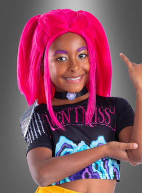 Ein Kind mit leuchtend pinkem Haar, das im Stil der K-Pop-Perücke „Demon Hunters Mira“, mit buntem Make-up und einem schwarzen Crop-Top mit auffälligen Mustern gestylt ist, lächelt und hebt einen Arm vor einem grauen Hintergrund mit Farbverlauf.