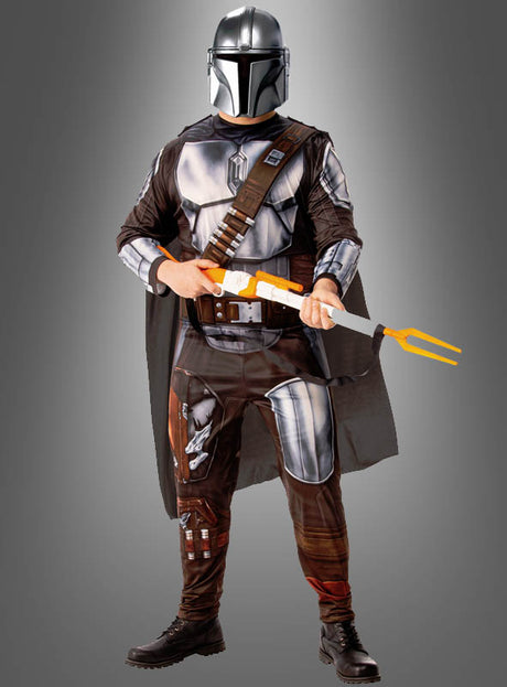 Eine Person, die das „Mandalorian Herrenkostüm Beskar Star Wars“ trägt und eine Spielzeugwaffe mit orangefarbener Spitze in der Hand hält, steht vor einem schlichten grauen Hintergrund.