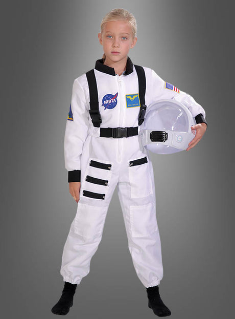 Ein Kind im Astronauten-Space-Shuttle-Kinderkostüm mit NASA- und Flaggen-Aufnähern steht mit einem Helm in der Hand vor einem schlichten grauen Hintergrund – ein perfektes Weltraumkostüm, das junge Weltraumforscher zum Träumen anregt.