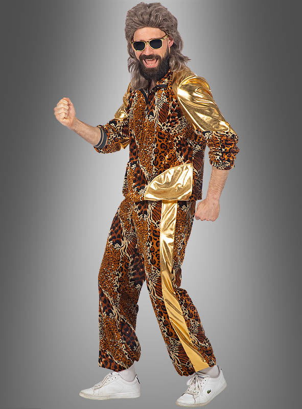Eine Person präsentiert den „Retro Leoparden Trainingsanzug“ – ein Karnevalskostüm in Gold und Leopardenmuster im Stil eines klassischen Trainingsanzugs aus den 80er Jahren mit passender Hose –, kombiniert mit Sonnenbrille, einem künstlichen Bart, einer Perücke und weißen Sneakers, vor einem grauen Hintergrund.