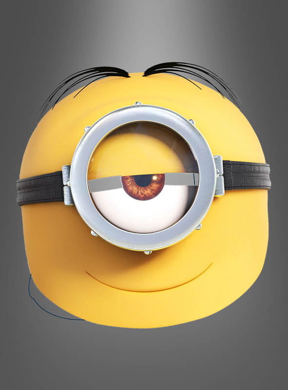 Im Mittelpunkt eines grauen Hintergrunds mit Farbverlauf steht eine gelbe, runde Comicfigur mit einem großen Auge hinter einer silbernen Schutzbrille mit schwarzem Riemen und einem dezenten Lächeln, die der „Minion Maske Stuart Kinder“ sehr ähnlich sieht – ideal für Fans von „Ich – Einfach unverbesserlich“ und perfekt für jede „Minion Maske Kinder“-Sammlung.