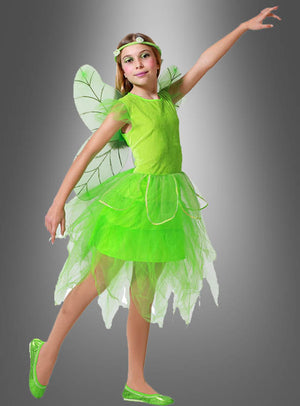 Ein Mädchen posiert in dem „Grüne Fee“-Kinderkostüm mit Flügeln, das aus zarten Flügeln, einem Tüllrock, einem passenden Haarband und passenden Schuhen besteht, vor einem grauen Hintergrund mit Farbverlauf.