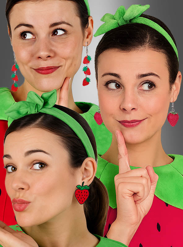 Drei Frauen tragen grüne Stirnbänder, Fruchtschmuck in Form von Erdbeer-Ohrringen – als Hänger oder Stecker – sowie aufeinander abgestimmte grüne und rote Outfits. Jede von ihnen zeigt einen einzigartigen Gesichtsausdruck – nachdenklich, zeigend oder die Lippen spitzend –, der den verspielten Charakter von Sommer-Modeschmuck einfängt.