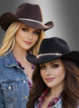 Zwei Frauen, die „Cowboy Hut mit Strass Deluxe“-Hüte tragen, kombiniert mit karierten Hemden und Jeansjacken, posieren vor einem neutralen Hintergrund mit Farbverlauf.