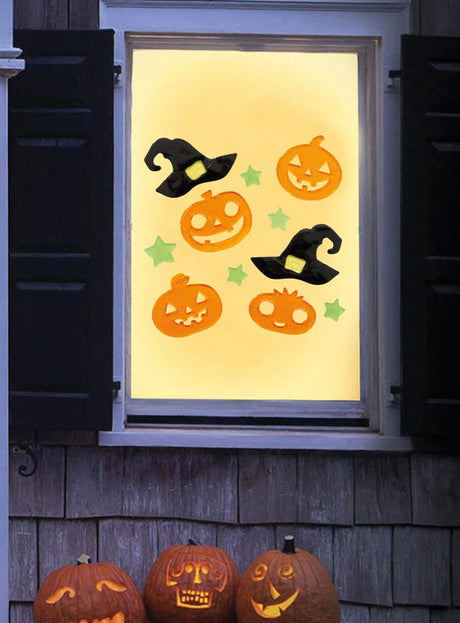 Ein mit dem Halloween-Fenster-Deko-Set aus Gel (20 x 19 cm) geschmücktes Fenster zeigt wiederverwendbare Gel-Aufkleber in Form von Kürbissen, Hexenhüten und Sternen. Unterhalb des Fensters stehen vier geschnitzte Kürbislaternen auf einem Sims, wodurch dieses Set zu einem idealen festlichen Akzent für Ihr Zuhause wird.
