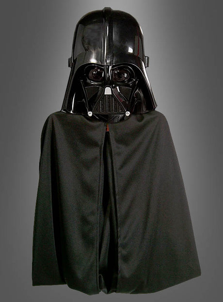 Eine Person, die den „Darth Vader Umhang mit Maske“ trägt, der der ikonischen Figur aus der „Star Wars“-Reihe sehr ähnlich sieht, steht vor einem schlichten grauen Hintergrund.