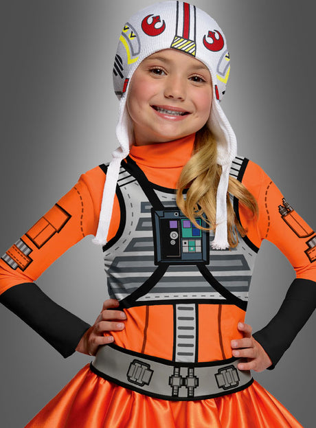 Ein lächelndes Kind trägt das „Star Wars X-Wing Fighter“-Kostüm für Mädchen mit passendem orangefarbenem Helm und steht selbstbewusst mit den Händen in den Hüften vor einem grauen Hintergrund – ideal als cooles Star-Wars-Kinderkostüm oder Karnevalskostüm für Mädchen.