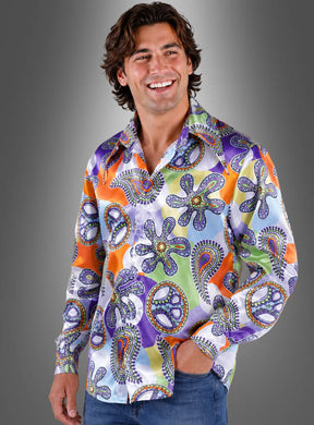 Ein Mann, der das „Peace Hippie Hemd Herren Cool Purple“ trägt – ein farbenfrohes Langarmhemd mit bunten, abstrakten Mustern –, steht vor einem grauen Hintergrund mit Farbverlauf und lächelt.