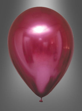 Ein einzelner Ballon aus der „Glossy Balloons“-Kollektion „Chrome Partydeko“ in glänzendem Rot mit Metallic-Optik schwebt vor einem grauen Hintergrund mit Farbverlauf und verleiht mit seiner glänzenden Chromoberfläche der Partydekoration das gewisse Etwas.