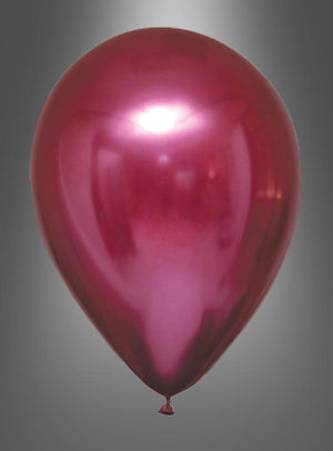 Ein einzelner Ballon aus der „Glossy Balloons“-Kollektion „Chrome Partydeko“ in glänzendem Rot mit Metallic-Optik schwebt vor einem grauen Hintergrund mit Farbverlauf und verleiht mit seiner glänzenden Chromoberfläche der Partydekoration das gewisse Etwas.