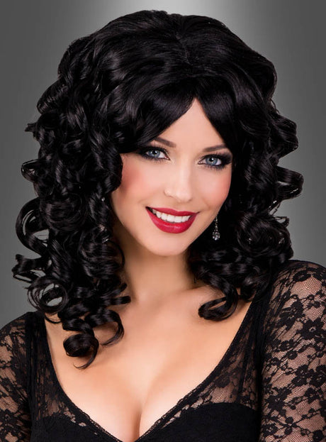 Eine Frau mit langen, lockigen schwarzen Haaren, die zu einer „Spirallocken-Perücke mit Glanz“ frisiert sind, trägt ein schwarzes Spitzenoberteil, roten Lippenstift und Ohrringe und lächelt vor einem grauen Hintergrund mit Farbverlauf in die Kamera.