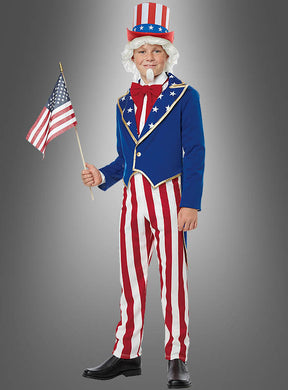 Eine als Uncle Sam verkleidete Person hält eine amerikanische Flagge in der Hand. Das Uncle-Sam-USA-Kostüm für Kinder – ideal als USA-Kostüm oder Karnevalskostüm für Kinder – besteht aus einer blauen Jacke, einer rot-weiß gestreiften Hose, einem Zylinder und einer weißen Perücke mit Bart.