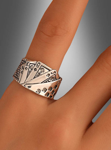 Der „Spielkarten Ring Casino verstellbar“, ein silberner, verstellbarer Ring mit Spielkarten, die einen Royal Flush zeigen, wird am Finger einer Person vor einem neutralen Hintergrund präsentiert.