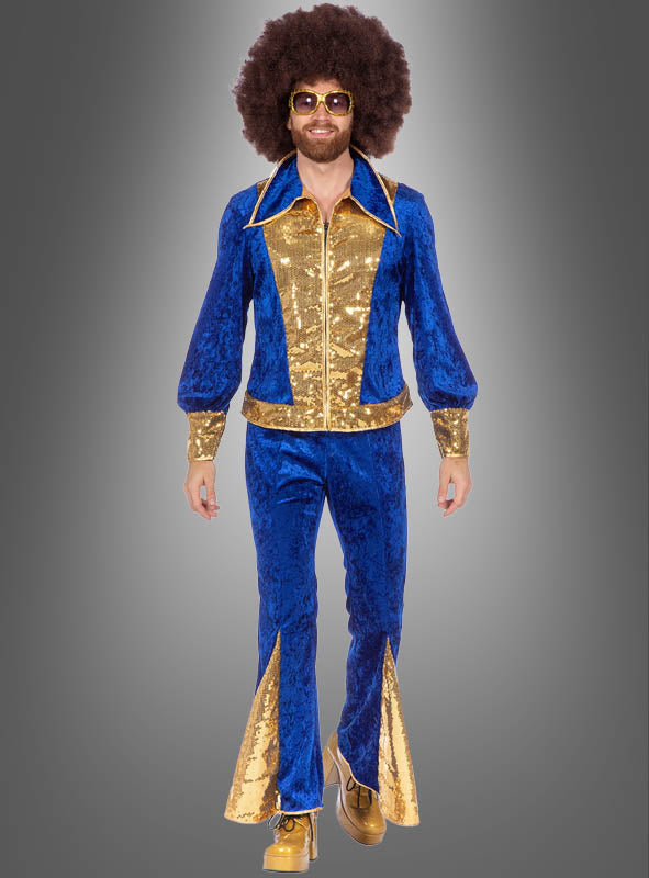 Eine Person, die den „Glitzer Disco Anzug“ in Blau-Gold trägt – mit ausgestelltem Hosenbein und Pailletten-Details –, dazu goldene Schuhe, eine große Afro-Perücke und eine Sonnenbrille, vor einem grauen Hintergrund mit Farbverlauf.