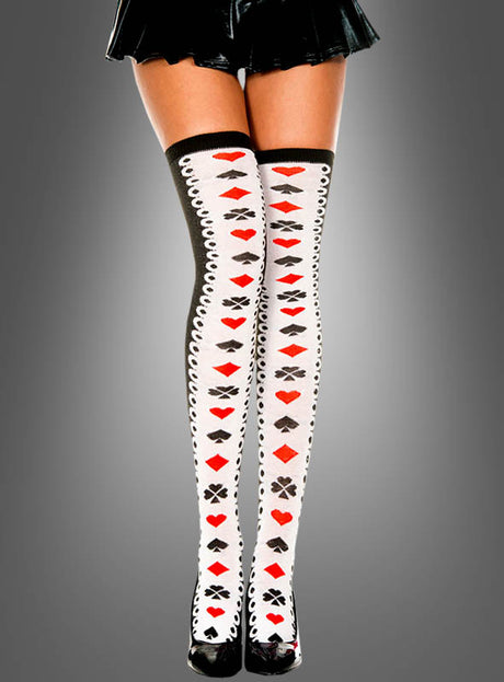 Eine Person trägt kniehohe, halterlose „Kartenspiel“-Strümpfe mit Spielkartensymbolen und schwarzen High Heels, die vor einem grauen Hintergrund vom mittleren Oberschenkel abwärts zu sehen sind – ein perfektes „Alice im Wunderland“-Accessoire für jedes Herzkönigin-Kostüm.