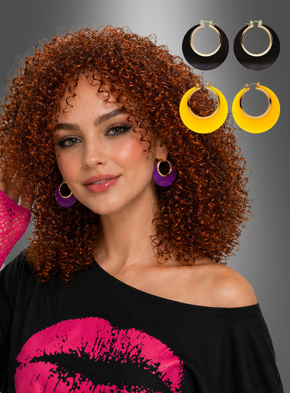 Eine Frau mit lockigem rotem Haar trägt ein schwarzes Oberteil mit einem rosa Lippenprint und lila Creolen, während neben ihr drei Paare „Vintage Ohrringe in verschiedenen Farben“ von Rockabilly Accessoires – hier in Schwarz und Gelb abgebildet – präsentiert werden, die jede 50er-Jahre-Kostüm perfekt ergänzen.