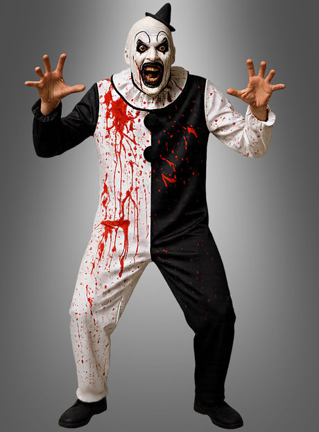 Eine Person, die das Kostüm „Blutiger Horrorclown – Erwachsene“ trägt – ein schwarz-weißes Design mit einer furchterregenden Maske und künstlichen Blutflecken –, posiert bedrohlich mit erhobenen Armen und gespreizten Fingern vor einem grauen Hintergrund.