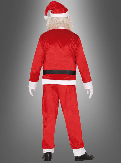 Eine Person in einem preiswerten Weihnachtsmannkostüm steht mit dem Rücken zur Kamera vor einem grauen Hintergrund mit Farbverlauf.