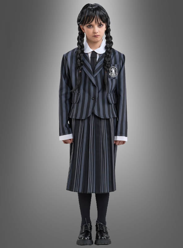 Ein Mädchen trägt das „Original Wednesday“-Kostüm für Kinder – eine schwarz-grau gestreifte Schuluniform mit langen, schwarz geflochtenen Haaren –, steht vor einem grauen Hintergrund mit Farbverlauf und blickt direkt in die Kamera, wodurch der ikonische Look der Addams Family perfekt eingefangen wird.