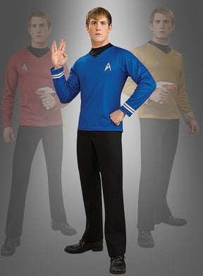 Eine Person, die die blaue STAR TREK-Uniform aus Film XI trägt und als Wissenschaftsoffizier verkleidet ist, führt den vulkanischen Gruß aus; im Hintergrund sind verblasste Gestalten in roten und gelben Star-Trek-Uniformen zu sehen.
