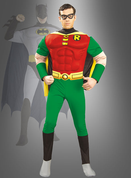 Ein Mann, der ein „Deluxe Muskel-Shirt“-Robin-Filmkostüm trägt, steht selbstbewusst mit den Händen in den Hüften da; im Hintergrund vervollständigt eine schemenhafte Batman-Figur das klassische Superhelden-Kostüm-Duo.