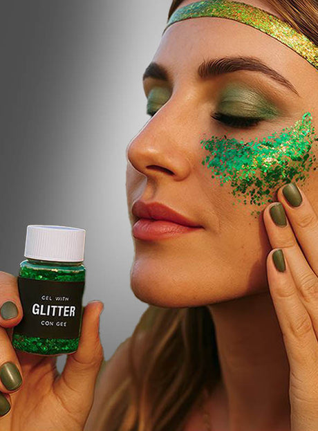 Eine Person trägt Glittergel-Make-up in verschiedenen Grüntönen auf ihre Wange auf und präsentiert so einen funkelnden Glitzer-Make-up-Look. Dazu trägt sie passenden grünen Lidschatten, grünen Nagellack und ein glänzendes grünes Stirnband.