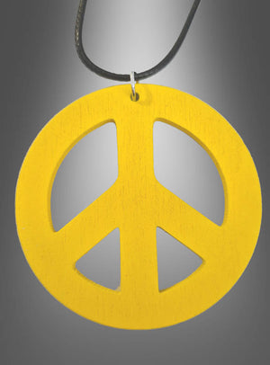 Eine Peace-Kette aus Holz im Stil der 70er Jahre mit einem gelben, 6,50 cm großen Peace-Zeichen-Anhänger hängt an einer schwarzen Kordel vor einem grauen Farbverlaufshintergrund – ideal, um deinem Hippie-Kostüm einen authentischen Touch zu verleihen.