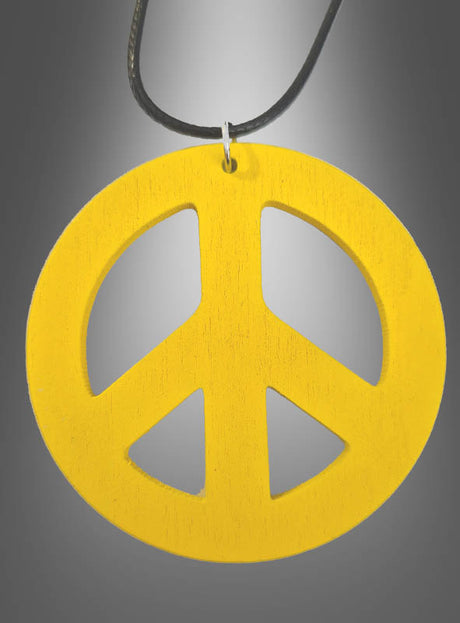 Eine Peace-Kette aus Holz im Stil der 70er Jahre mit einem gelben, 6,50 cm großen Peace-Zeichen-Anhänger hängt an einer schwarzen Kordel vor einem grauen Farbverlaufshintergrund – ideal, um deinem Hippie-Kostüm einen authentischen Touch zu verleihen.