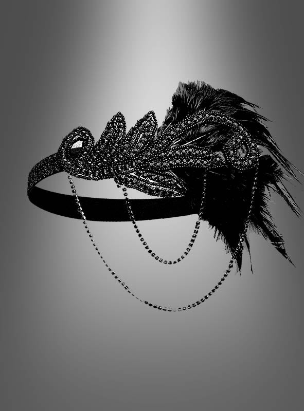20er-Jahre-Kopfschmuck mit Strass „Alice“ – ein schwarzes, mit Perlen besetztes Flapper-Haarband mit dekorativen Federn und herabhängenden Ketten, inspiriert vom Stil der 20er Jahre. Präsentiert auf einem grauen Farbverlauf. Perfekt als eleganter Kopfschmuck im Stil der 20er Jahre zu deinem Charleston-Kleid.
