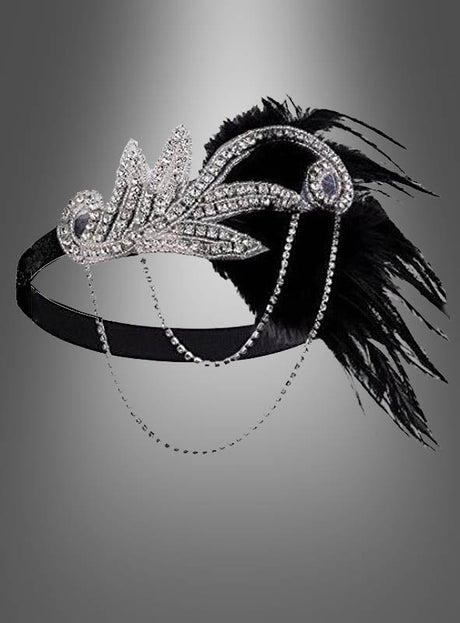 Der 20er-Jahre-Kopfschmuck „Alice“ ist ein schwarzes Stirnband, das mit silbernen Strasssteinen, Zierketten und eleganten schwarzen Federn verziert ist und dessen Design vom Gatsby-Stil der 1920er Jahre inspiriert ist – damit ist es das ideale 20er-Jahre-Haarband, um Ihr Charleston-Kleid für einen authentischen Vintage-Look zu vervollständigen.