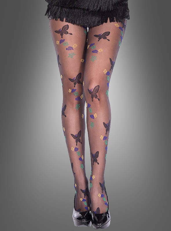 Ein Model präsentiert die Strumpfhose „Schmetterling“ aus transparentem schwarzem Stoff, verziert mit zarten Schmetterlings- und Blumenmotiven. Dazu trägt sie schwarze High Heels und einen Rock mit Fransen vor einem grauen Hintergrund mit Farbverlauf.
