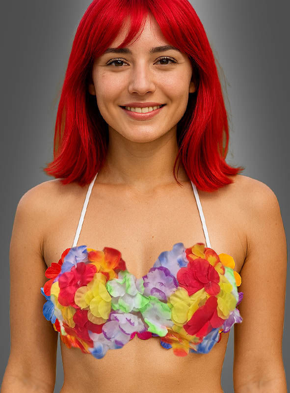 Eine Frau mit leuchtend roten Haaren lächelt und trägt das farbenfrohe Hawaii-Bikini-Oberteil „Karneval“ vor einem schlichten grauen Hintergrund.