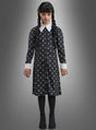 Ein junges Mädchen mit langen schwarzen Zöpfen trägt das „Wednesday Mädchen Kleid schwarz-weiß“ – ein klassisches, von der Addams Family inspiriertes schwarzes Kleid mit weißem Kragen und weißen Manschetten, dazu schwarze Strumpfhosen und Schuhe – und steht vor einem schlichten grauen Hintergrund – die perfekte Wahl für jeden Anlass, bei dem ein Wednesday-Kostüm gefragt ist.