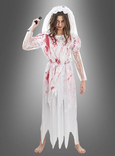 Vor einem grauen Hintergrund steht ein barfüßiges Mädchen im „Blutige Braut Carmilla“-Kinderkostüm – komplett mit einem weißen, blutbefleckten Brautkleid und Schleier, während es ein schwarzes Requisitenmesser in der Hand hält – die perfekte Inspiration für jedes gruselige Halloween-Kinderkostüm.