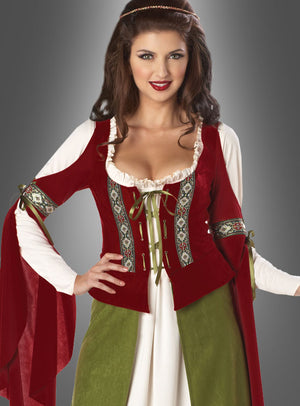 Eine Frau, die das „Mittelalterkleid Edeldame Adelheid“ trägt – ein mittelalterlich inspiriertes Kleid mit roter Weste, weißem Unterhemd, grünem Rock und bestickten Details –, posiert vor einem grauen Hintergrund.