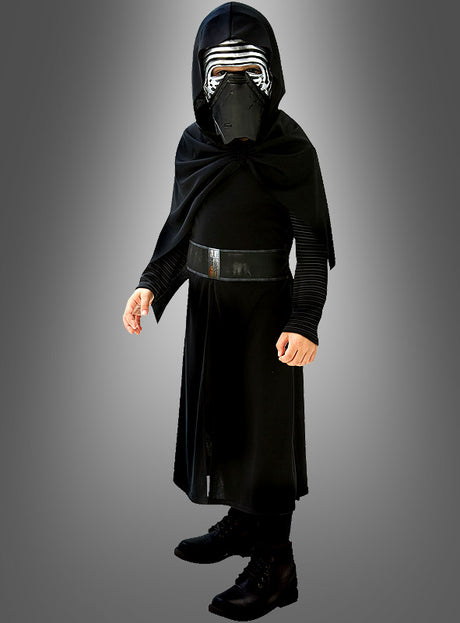 Vor einem schlichten grauen Hintergrund steht ein Kind, das eine schwarze Robe, einen Umhang und eine Maske mit silbernen Verzierungen trägt – ein beeindruckendes „Kylo Ren Classic“-Kinderkostüm, das dem Star Wars-Charakter perfekt nachempfunden ist. Dieses originale Star Wars-Kinderkostüm besticht durch authentische, von der Saga inspirierte Details und wird unter Original-Star-Wars-Lizenz hergestellt.