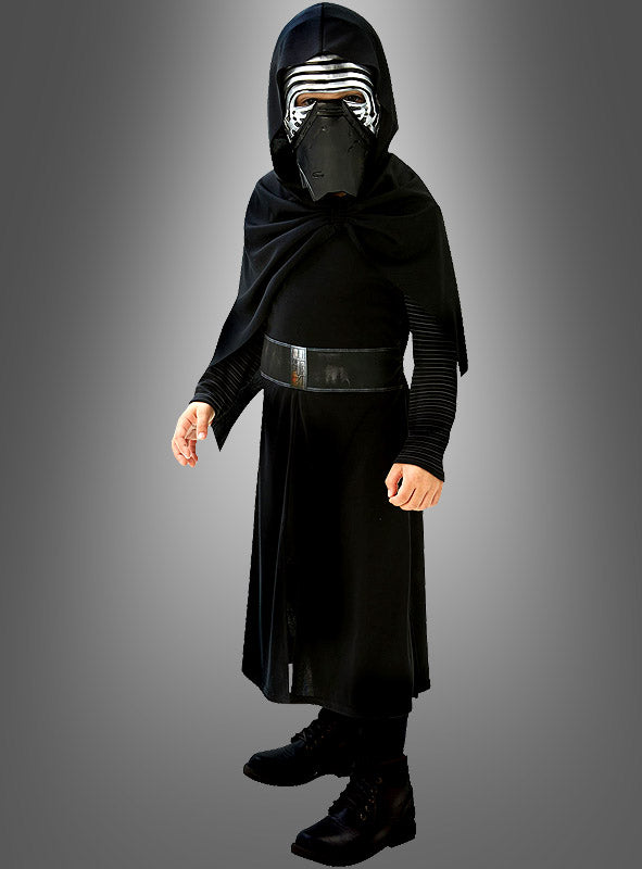 Vor einem schlichten grauen Hintergrund steht ein Kind, das eine schwarze Robe, einen Umhang und eine Maske mit silbernen Verzierungen trägt – ein beeindruckendes „Kylo Ren Classic“-Kinderkostüm, das dem Star Wars-Charakter perfekt nachempfunden ist. Dieses originale Star Wars-Kinderkostüm besticht durch authentische, von der Saga inspirierte Details und wird unter Original-Star-Wars-Lizenz hergestellt.