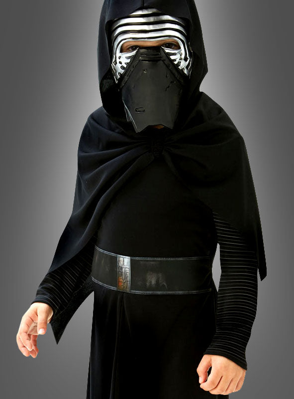 Ein Kind im „Kylo Ren Classic Kinderkostüm“ – bestehend aus einem schwarzen Kapuzenmantel und einer metallischen Maske – verkörpert die ikonische „Star Wars“-Figur perfekt. Dieses offiziell lizenzierte Original-„Star Wars“-Kostüm ist ideal für junge Fans, die einen authentischen Look suchen, und hebt sich deutlich von einem schlichten grauen Hintergrund ab.