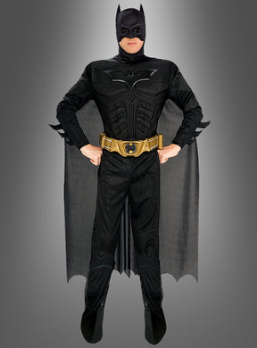 Eine Person, die das „Batman: The Dark Knight“-Kinofilm-Kostüm trägt – ein offizielles Batman-Lizenzprodukt, bestehend aus einem schwarzen Superhelden-Outfit mit Umhang und goldenem Werkzeuggürtel –, steht selbstbewusst mit den Händen in den Hüften vor einem grauen Hintergrund. Dieses Kostüm ist ideal für Fans, die ein authentisches „Batman: The Dark Knight“-Kostüm oder ein auffälliges Batman-Kostüm für Erwachsene suchen.