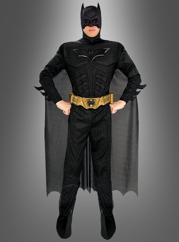 Eine Person, die das „Batman: The Dark Knight“-Kinofilm-Kostüm trägt – ein offizielles Batman-Lizenzprodukt, bestehend aus einem schwarzen Superhelden-Outfit mit Umhang und goldenem Werkzeuggürtel –, steht selbstbewusst mit den Händen in den Hüften vor einem grauen Hintergrund. Dieses Kostüm ist ideal für Fans, die ein authentisches „Batman: The Dark Knight“-Kostüm oder ein auffälliges Batman-Kostüm für Erwachsene suchen.
