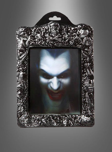Ein dekorativer Rahmen mit einem Linsenbild, das ein unheimliches Vampirgesicht zeigt – mit blasser Haut, roten Lippen und scharfen Reißzähnen vor einem dunklen Hintergrund mit Farbverlauf. Dieses „Wackelbild Halloween-Hologramm“ erzeugt einen auffälligen 3D-Effekt, der jeder Umgebung eine unheimliche Note verleiht.