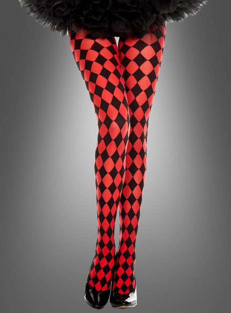 Eine Person, die eine rot-schwarze Harlekin-Strumpfhose und schwarze Schuhe trägt, steht mit gekreuzten Beinen vor einem grauen Hintergrund – ein stilvolles Karnevalskostüm mit einem auffälligen rot-schwarzen Harlekin-Muster (Rautenmuster).